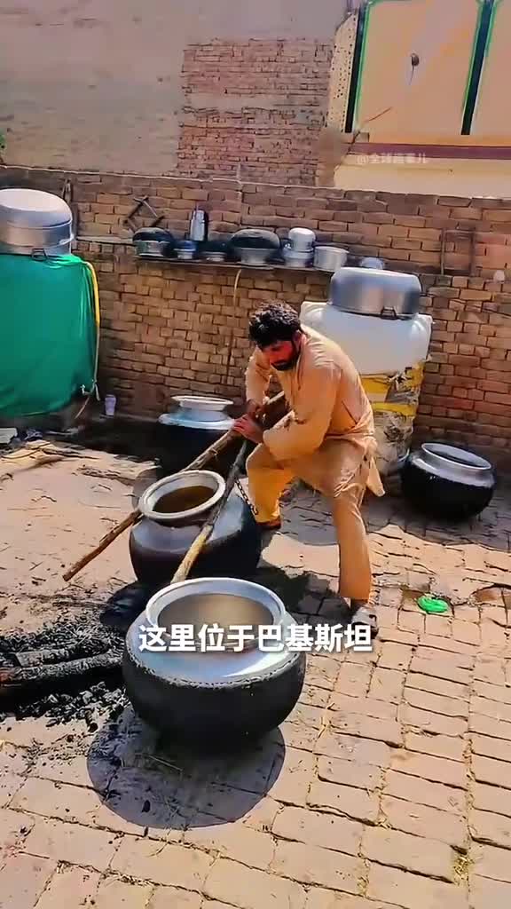 没有手柄的大锅居然要依靠木棍来搬动