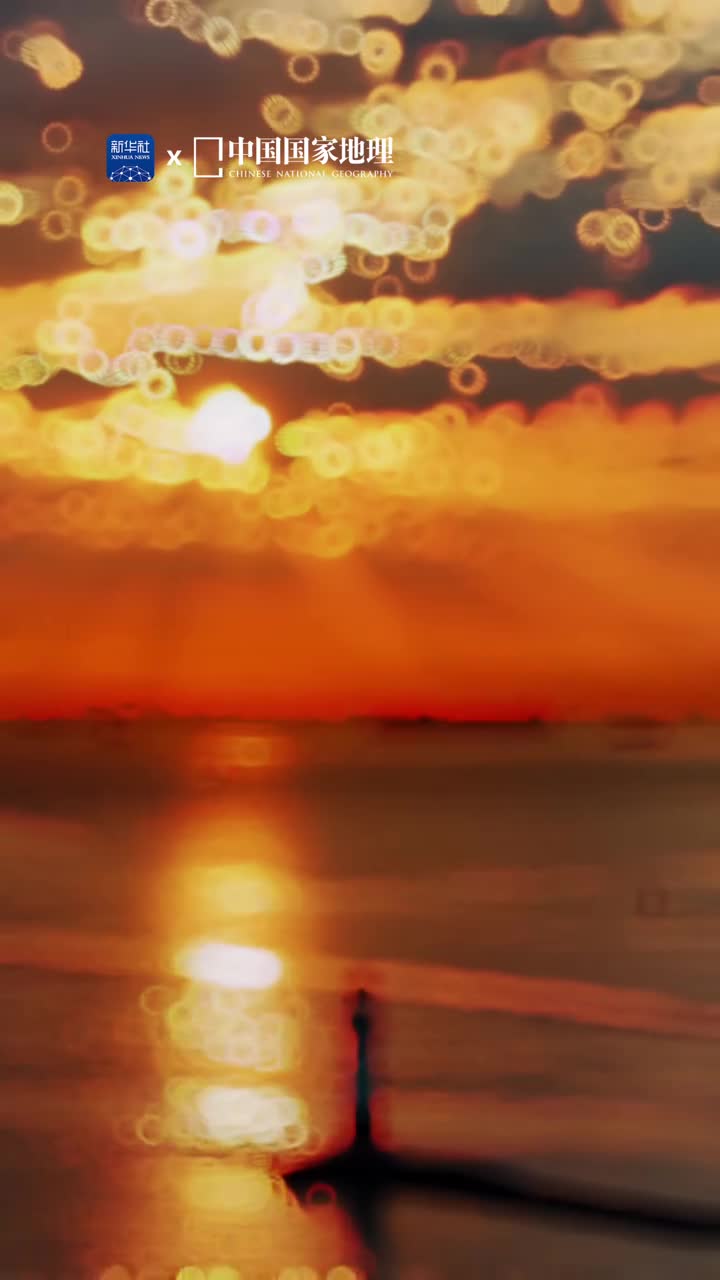 带你去看看上海的日出清晨太阳的第一抹光辉冲破云霞闪耀人间在晨辉的渲染下云朵如镶金边灿烂辉煌这里是位于长江和黄浦江交汇处的吴淞口