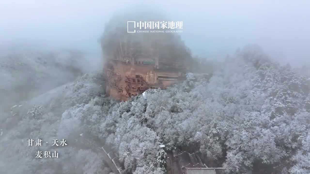 这一刻被雪落麦积山惊艳了今天是一带一路国际日让我们一睹千年丝路瑰宝的风采一场冬雪过后麦积山山顶和周围的山地森林被渲染成了水墨画唯独陡直的崖壁依然保持着砂岩的本色大小龛像密如蜂房傲雪凌霜一眼千年