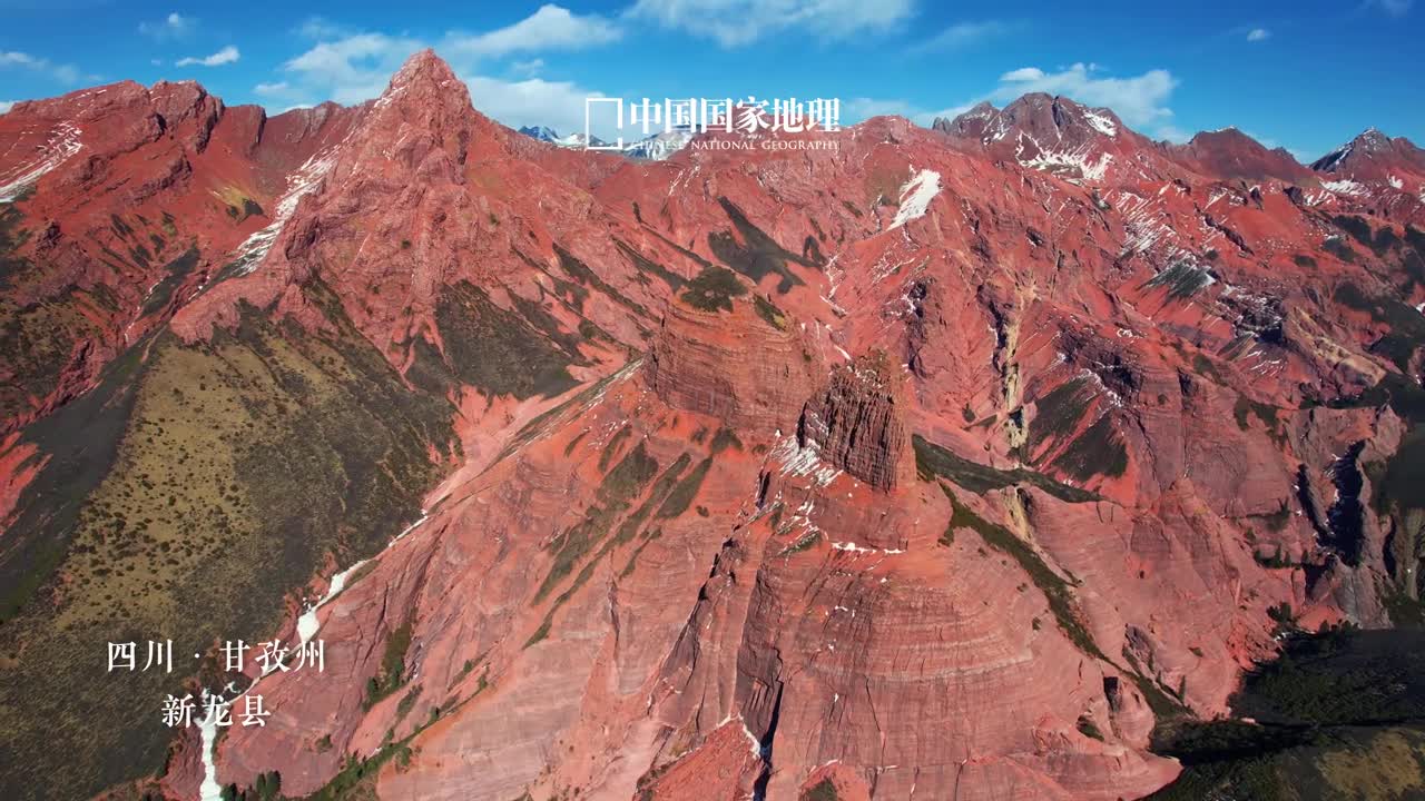 来川西赏大地红颜之美新龙红山丹霞是国内涉藏地区发现的海拔最高区域最广的丹霞地貌景区危崖劲露气势磅礴在自然的鬼斧神工下幻化出千怪万状如千年石堡奇鸟异兽佛塔神像由于大部分山峰高出雪线故除了灿若明霞的红艳还有积雪覆盖的净美如同川西大地上的一首冰与火之歌