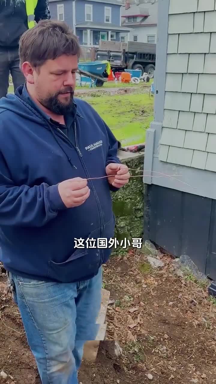 男子利用铜丝寻找打井位置看起来就像国内的寻龙尺