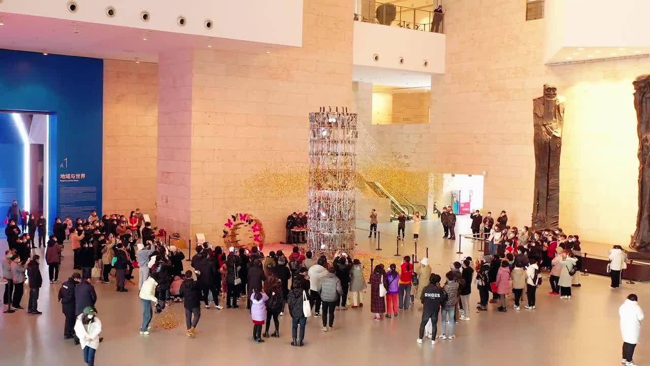 2022济南国际双年展参展作品大型冷烟花装置花彩艺术神柱绽放在山东美术馆开爆无数纷飞的玫瑰花瓣与蝴蝶在展厅中落下又被现场观众不断抛撒如同造梦空间带给人关于美的无限想象与奇妙体验