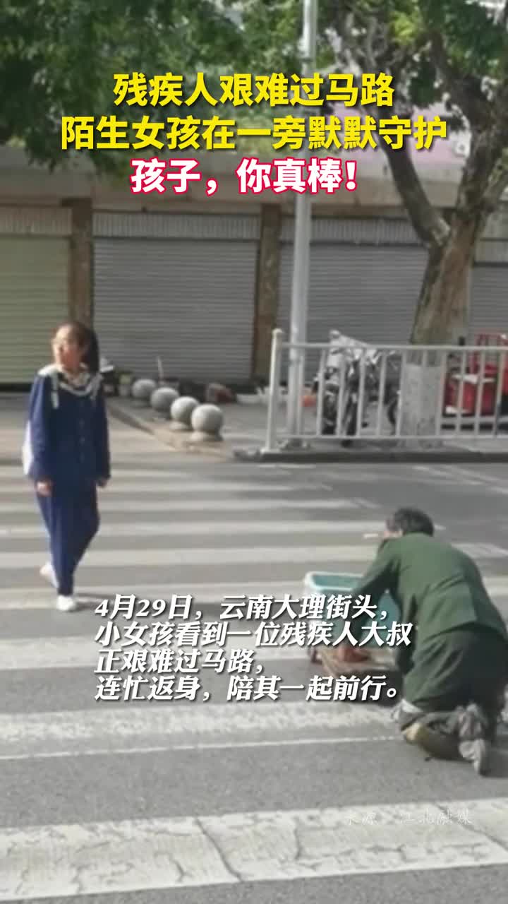残疾人艰难过马路陌生女孩在一旁默默守护孩子你真棒