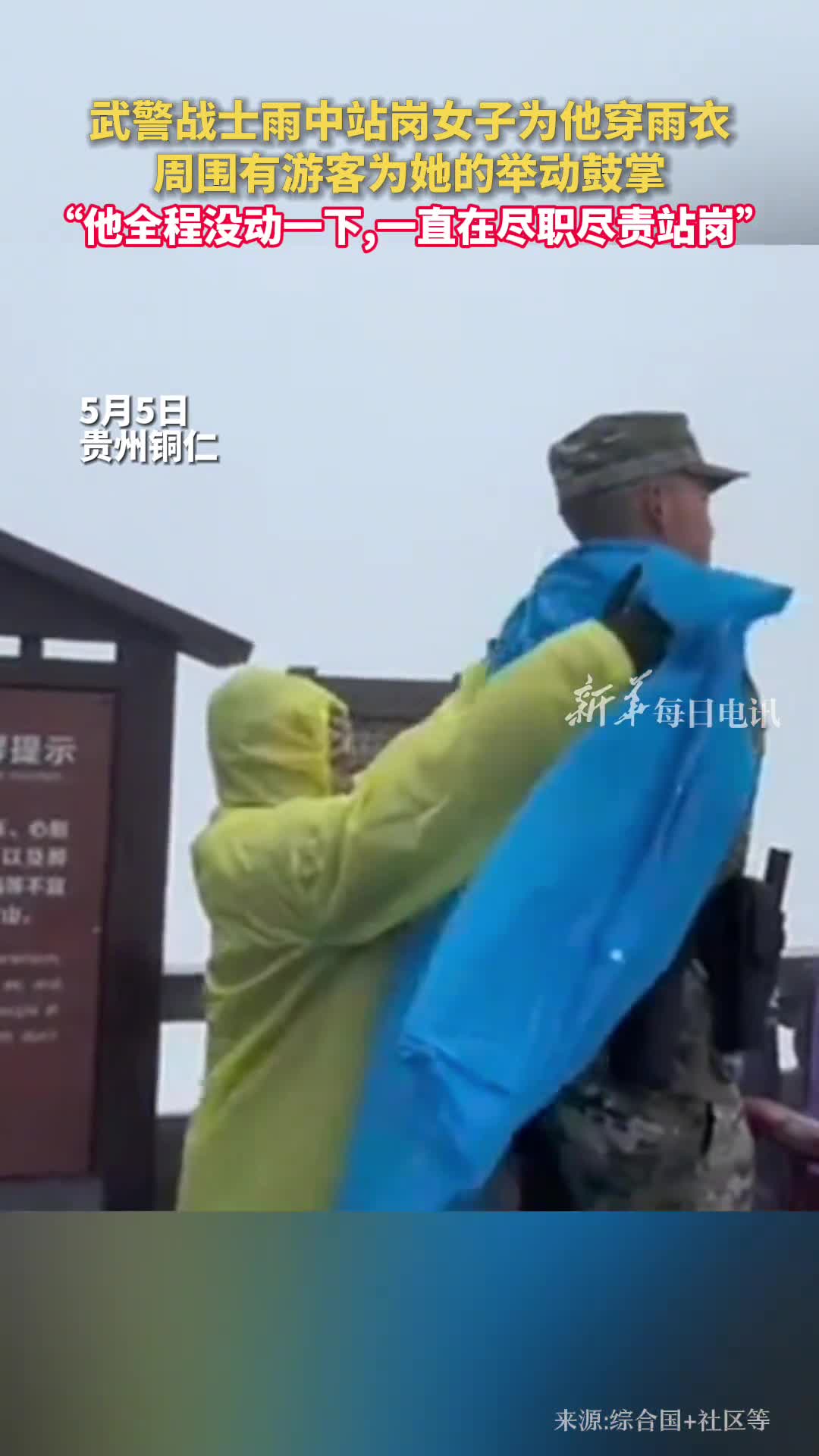武警战士雨中站岗女子为他穿雨衣周围有游客为她的举动鼓掌他全程没动一下一直在尽职尽责站岗