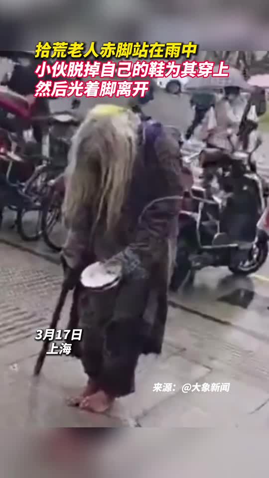 拾荒老人赤脚站在雨中小伙脱掉自己的鞋为其穿上然后光着脚离开