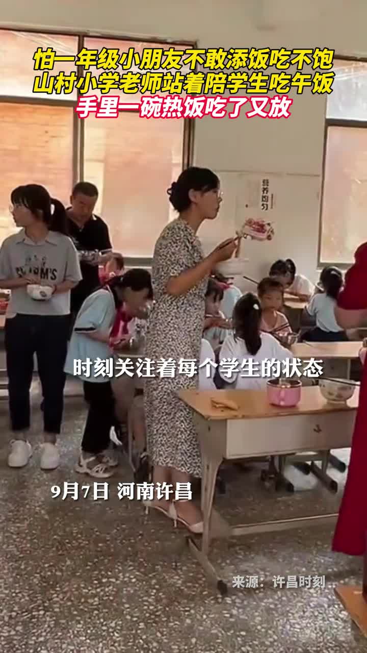 怕一年级小朋友不敢添饭吃不饱山村小学老师站着陪学生吃午饭手里一碗热饭吃了又放