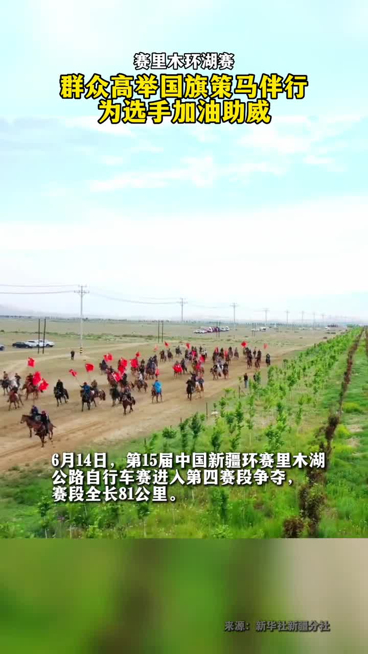 赛里木环湖赛群众高举国旗策马伴行为选手加油助威