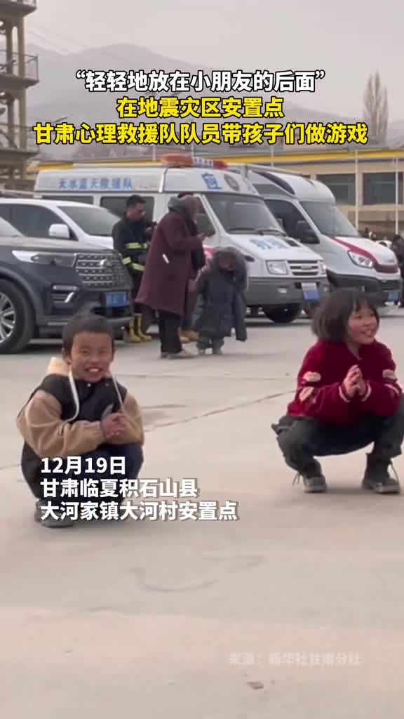 轻轻地放在小朋友的后面在地震灾区安置点甘肃心理救援队队员带孩子们做游戏