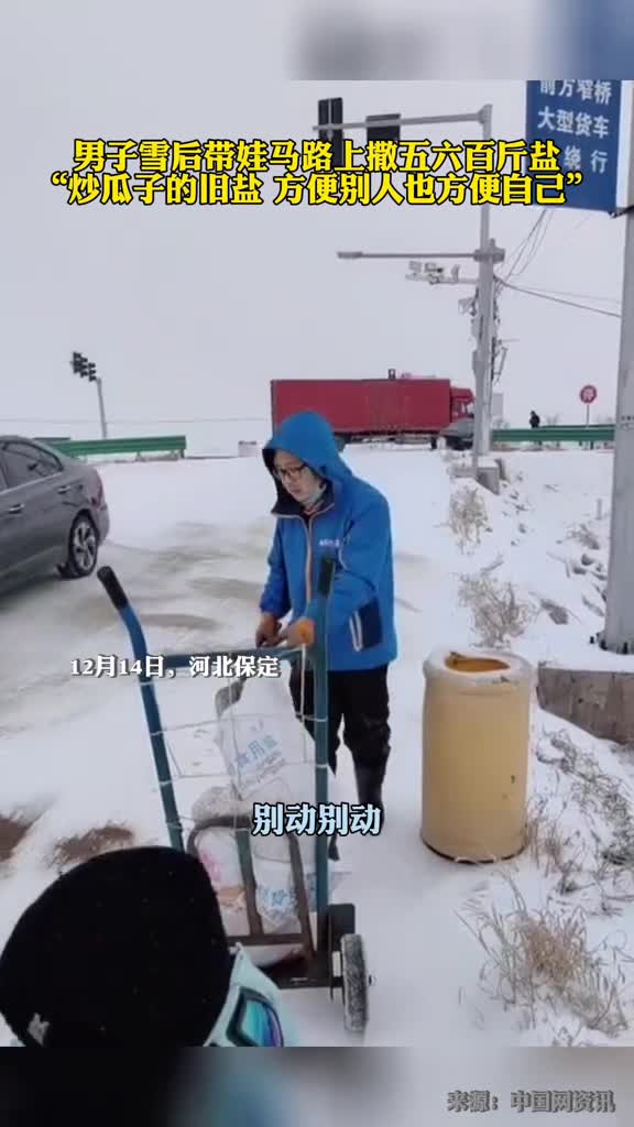男子雪后带娃在马路上撒盐