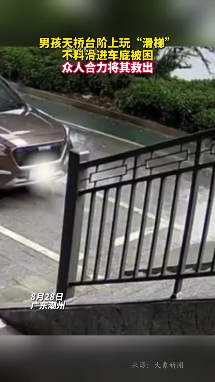 男孩天桥台阶上玩滑梯不料滑进车底被困众人合力将其救出