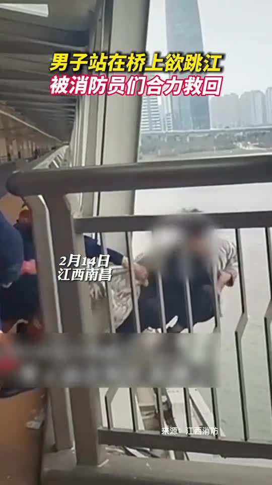 男子站在桥上欲跳江被消防员们合力救回
