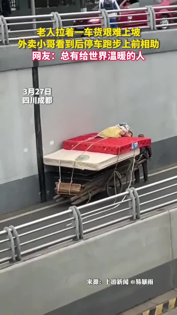 老人拉着一车货艰难上坡外卖小哥看到后停车跑步上前相助