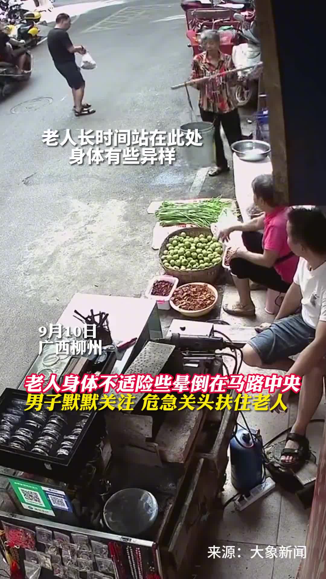 老人身体不适险些晕倒在马路中央路边男子默默关注危急关头扶住老人为白衣小伙点赞