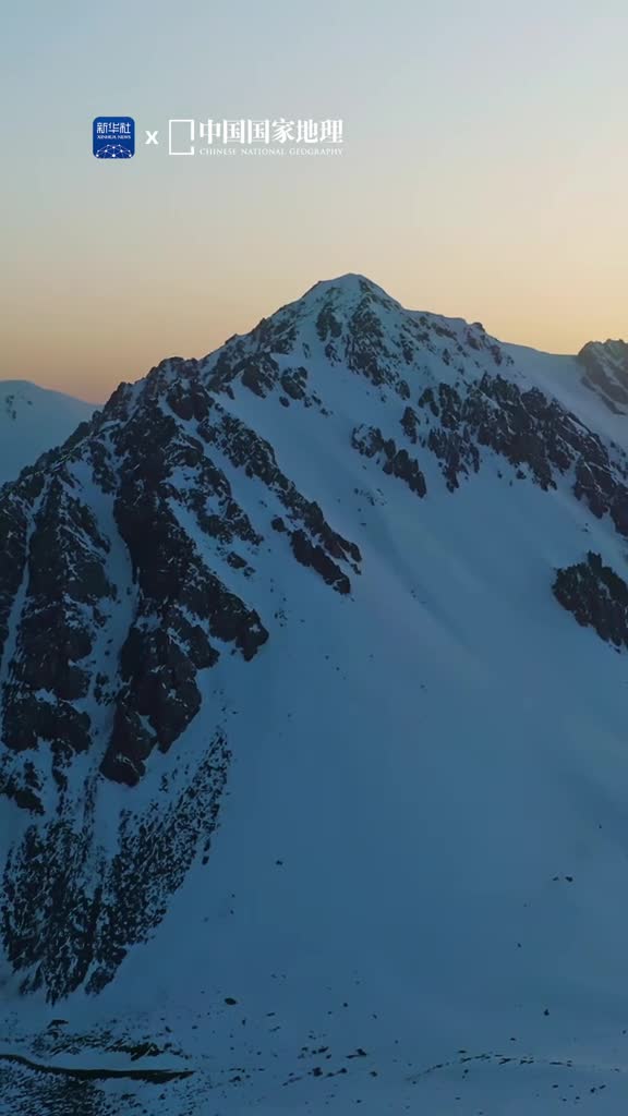 在青海与雪山深情对视位于青海省海北藏族自治州的岗什卡雪峰峰顶常年积雪蔚为壮观飞雪漫卷堆叠在苍茫雪域起伏的沟壑尽情展示大自然的鬼斧神工