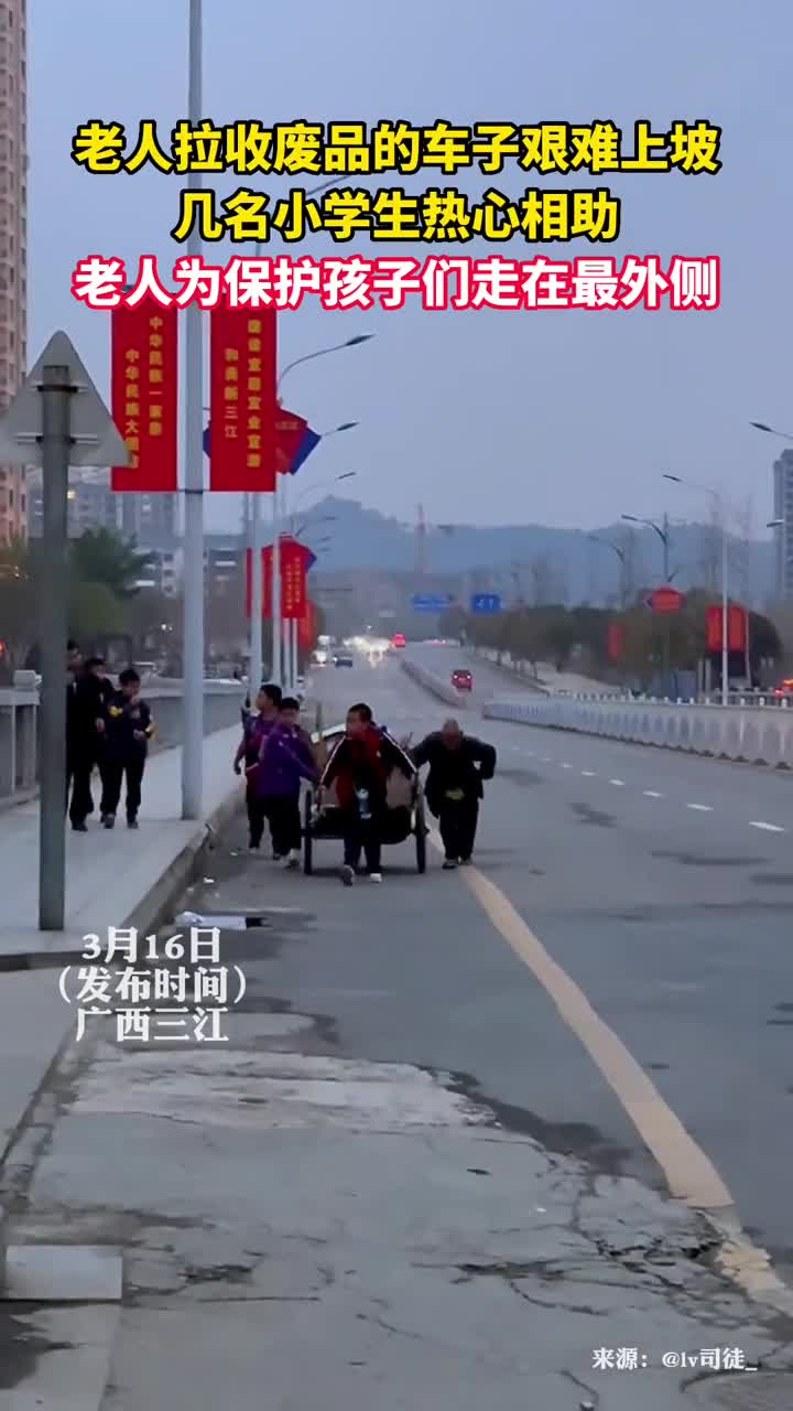 老人拉收废品的车子艰难上坡几名小学生热心相助老人为保护孩子们走在最外侧