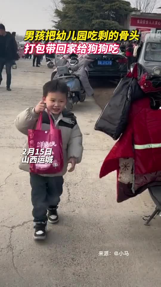 男孩把幼儿园吃剩的骨头打包带回家给狗狗吃