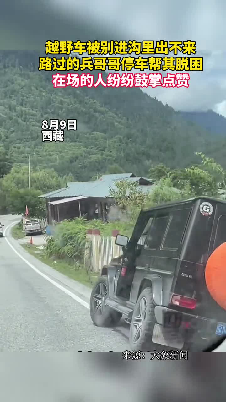 越野车被别进沟里出不来路过的兵哥哥停车帮其脱困在场的人纷纷鼓掌点赞