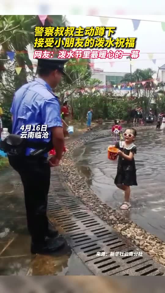 警察叔叔主动蹲下接受小朋友的泼水祝福
