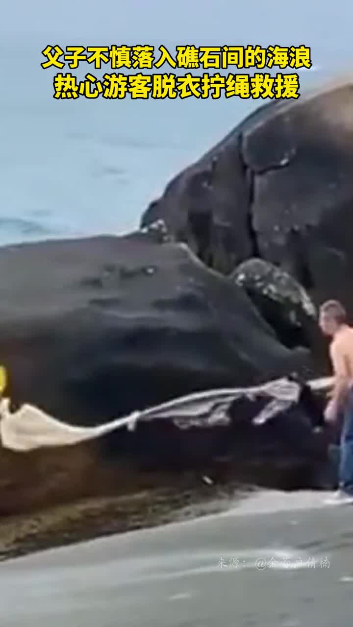 父子不慎落入礁石间的海浪热心游客脱衣拧绳救援