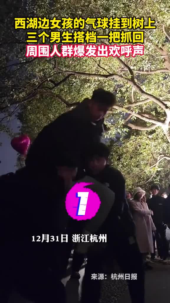 西湖边女孩的气球挂到树上三个男生搭档一把抓回周围人群爆发出欢呼声